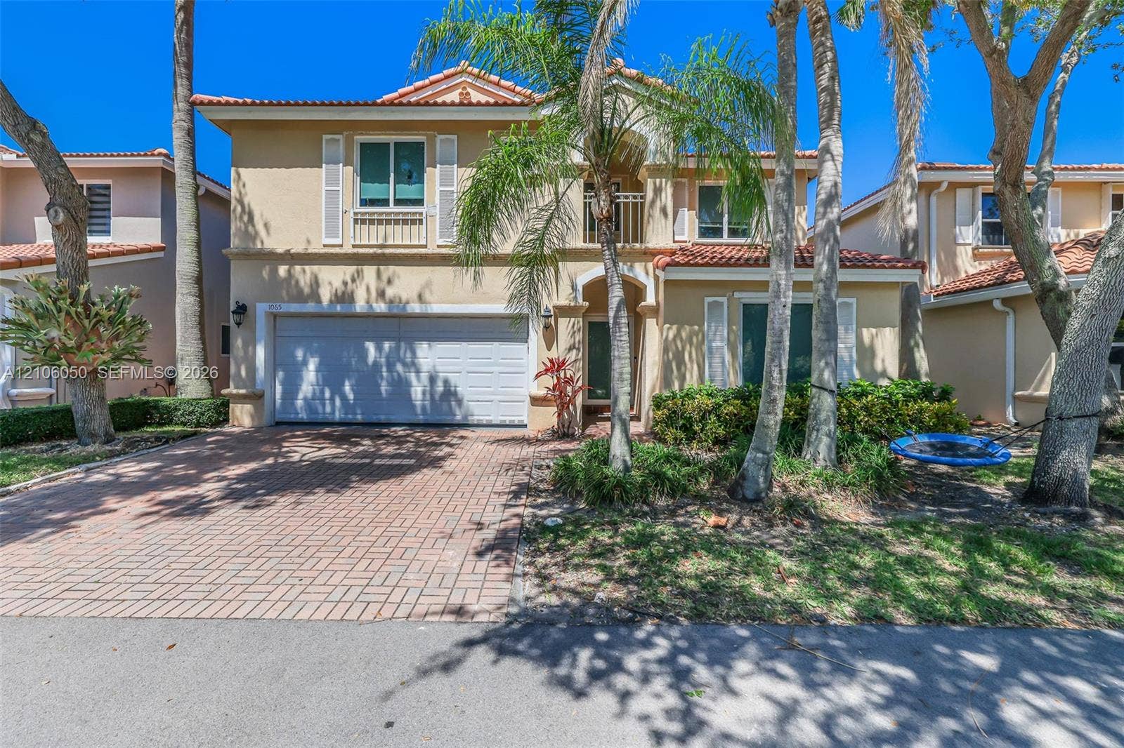 1065 Weeping Willow Way, #0, Hollywood, Hollywood, FL 33019 Two-story exterior featuring a stucco facade, red tile roofing, a paved driveway, a recessed entryway, and a second-story balcony