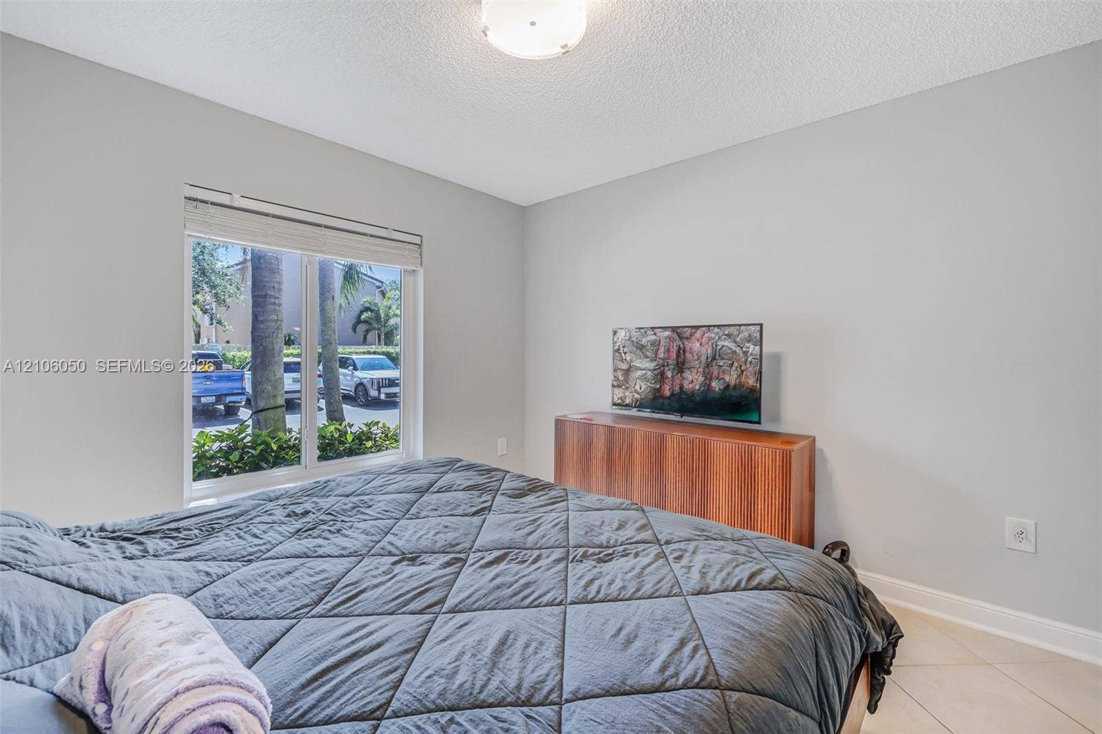 1065 Weeping Willow Way, #0, Hollywood, Hollywood, FL 33019 Neutral-toned room featuring a large window, light-colored tile flooring, and a central ceiling-mounted light fixture