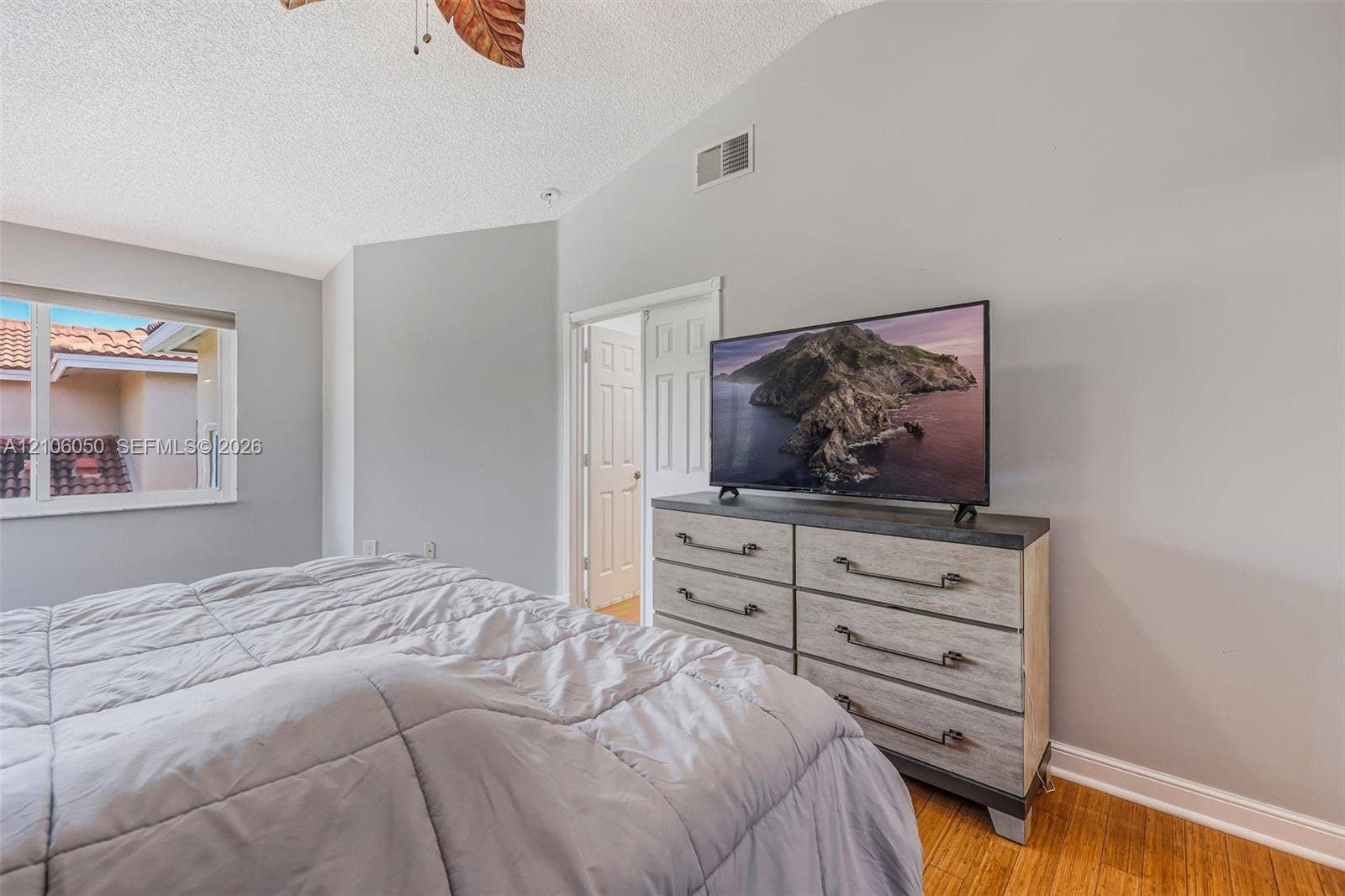 1065 Weeping Willow Way, #0, Hollywood, Hollywood, FL 33019 Vaulted ceiling with a ceiling fan, neutral wall paint, wood-finish flooring, and single-hung window with a view of exterior tile roofing