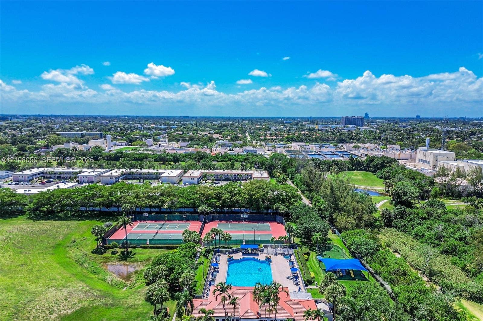 1065 Weeping Willow Way, #0, Hollywood, Hollywood, FL 33019 Recreational facilities featuring two hard-court tennis courts, a swimming pool with paved deck, and a shaded structure