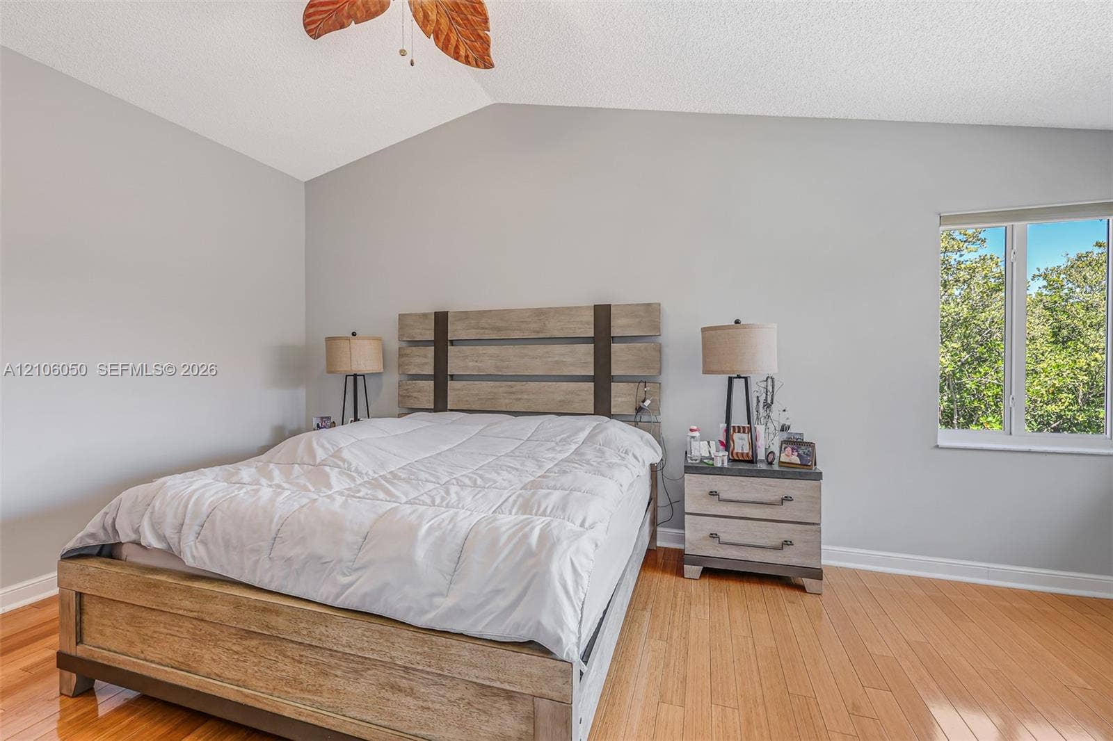 1065 Weeping Willow Way, #0, Hollywood, Hollywood, FL 33019 Vaulted ceilings, wood-finish flooring, and natural light from a window with exterior greenery