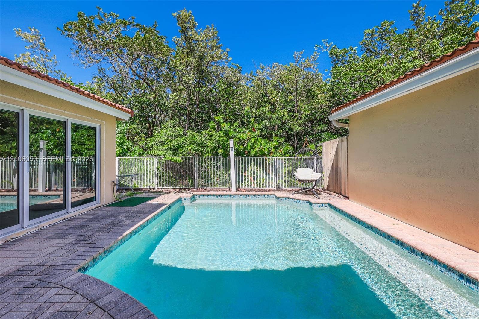 1065 Weeping Willow Way, #0, Hollywood, Hollywood, FL 33019 Private outdoor area featuring an in-ground swimming pool, stone-paver decking, sliding glass doors, and a metal perimeter fence