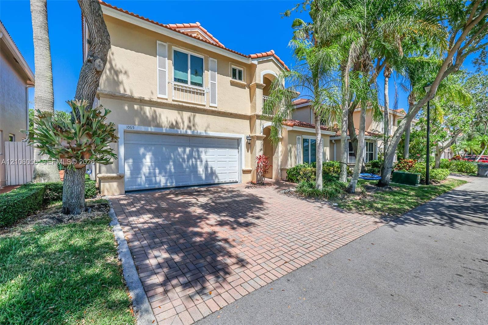 1065 Weeping Willow Way, #0, Hollywood, Hollywood, FL 33019 Stucco exterior residence featuring a clay tile roof, a paver driveway, an attached two-car garage, and established landscaping