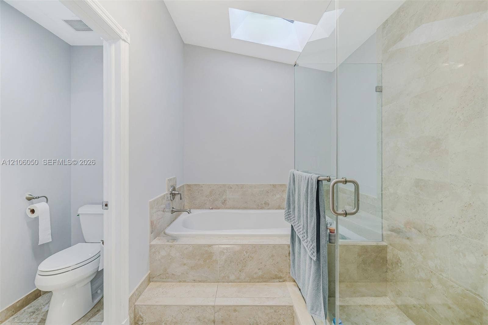 1065 Weeping Willow Way, #0, Hollywood, Hollywood, FL 33019 Built-in drop-in bathtub with stone-surround, frameless glass-enclosed shower, skylight, and neutral wall-mounted toilet