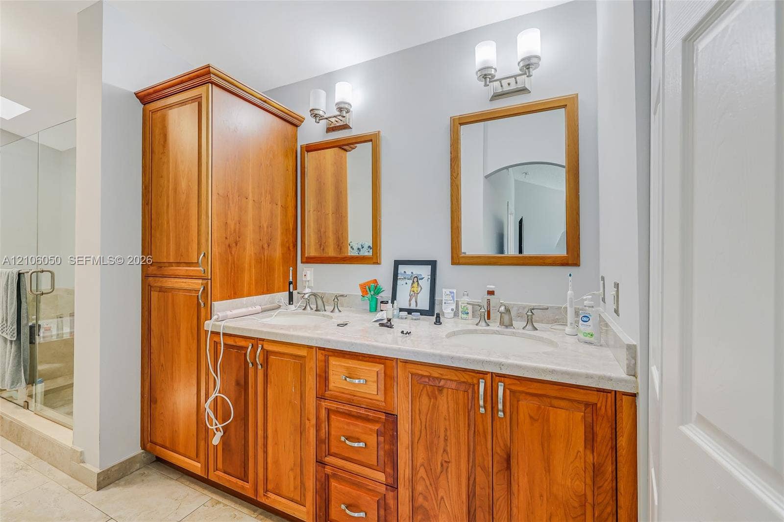 1065 Weeping Willow Way, #0, Hollywood, Hollywood, FL 33019 Dual-sink vanity with natural wood cabinetry, stone countertop, matching wood-framed mirrors, and brushed metal wall-mounted lighting