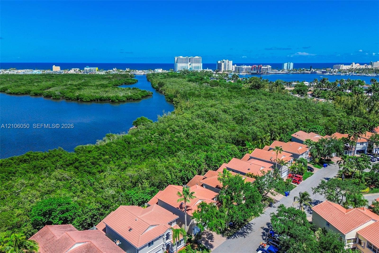 1065 Weeping Willow Way, #0, Hollywood, Hollywood, FL 33019 Aerial perspective of a coastal residential community featuring tile roofs, lush natural vegetation, expansive waterways, and a clear horizon line