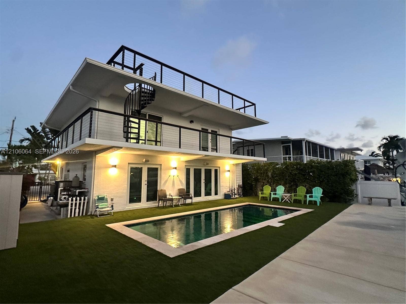 179 Azalea Street, Islamorada, FL 33070 Multi-level exterior featuring a private in-ground pool, expansive rooftop deck with cable railings, integrated spiral staircase, and exterior wall-mounted lighting