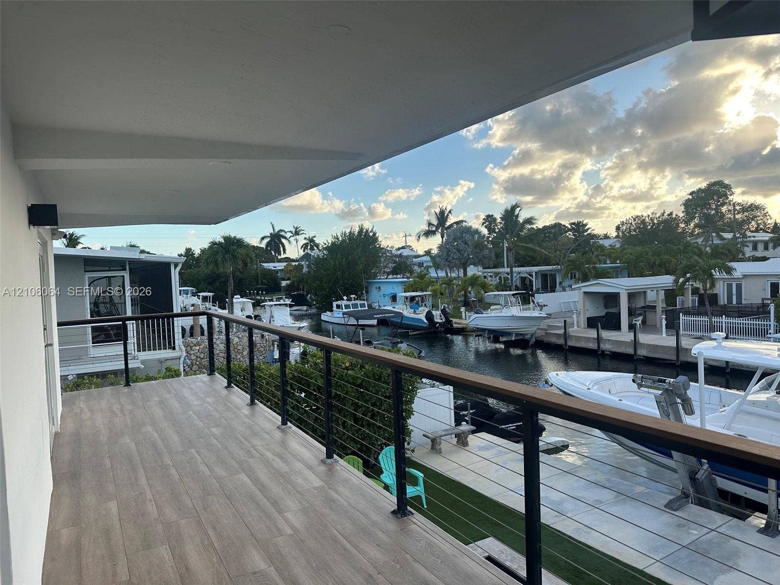 179 Azalea Street, Islamorada, FL 33070 Covered balcony featuring wood-finish flooring and a black metal railing with cable infill