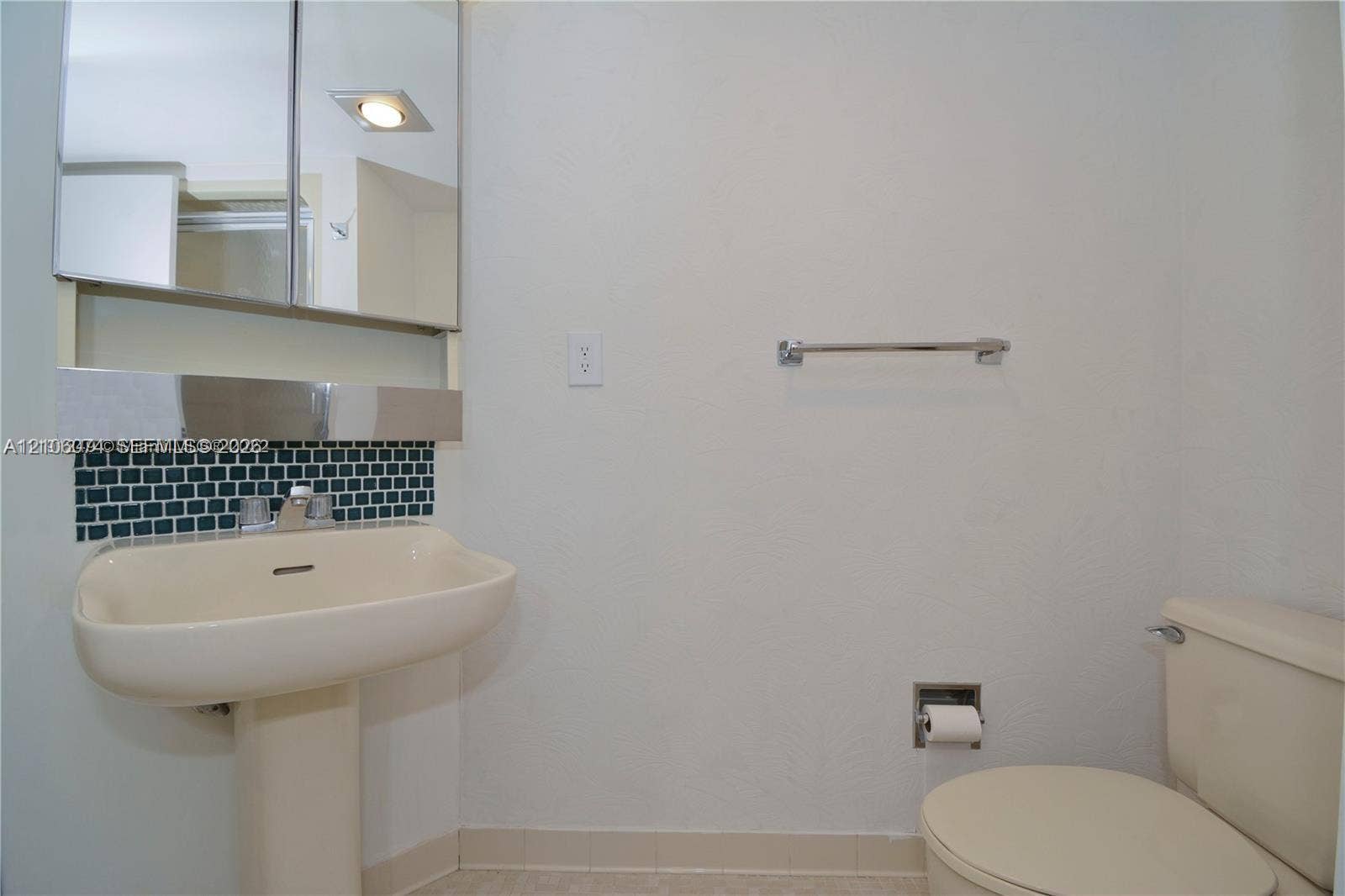 300 Three Islands Boulevard, #308, Hallandale Beach, Hallandale Beach, FL 33009 2nd Bath with Pedestal sink & shower with a single-handle faucet, mirrored medicine cabinet, geometric mosaic tile backsplash, and polished chrome hardware