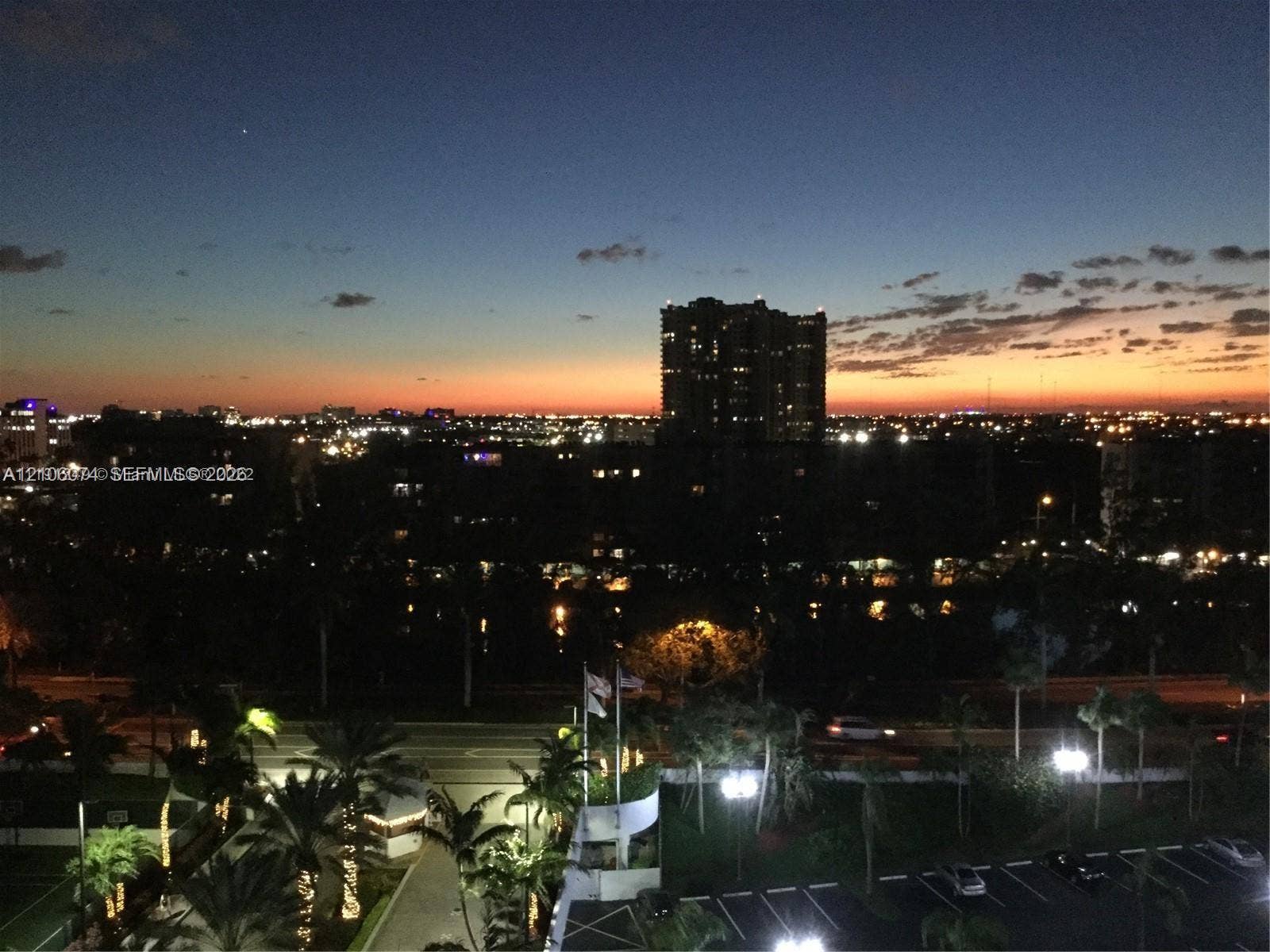 300 Three Islands Boulevard, #308, Hallandale Beach, Hallandale Beach, FL 33009 Panoramic city skyline featuring illuminated high-rise buildings and sunset horizon
