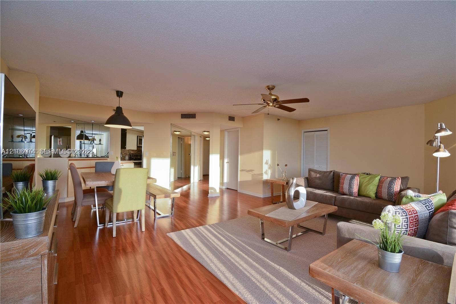 300 Three Islands Boulevard, #308, Hallandale Beach, Hallandale Beach, FL 33009 Open-concept living area featuring wood-finish flooring, recessed lighting, ceiling fan, and mirrored wall accents
