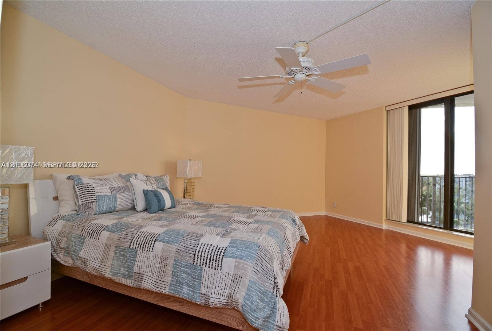 300 Three Islands Boulevard, #308, Hallandale Beach, Hallandale Beach, FL 33009 Room featuring wood-finish flooring, a white ceiling fan with integrated lighting, and glass sliding doors providing access to an exterior balcony