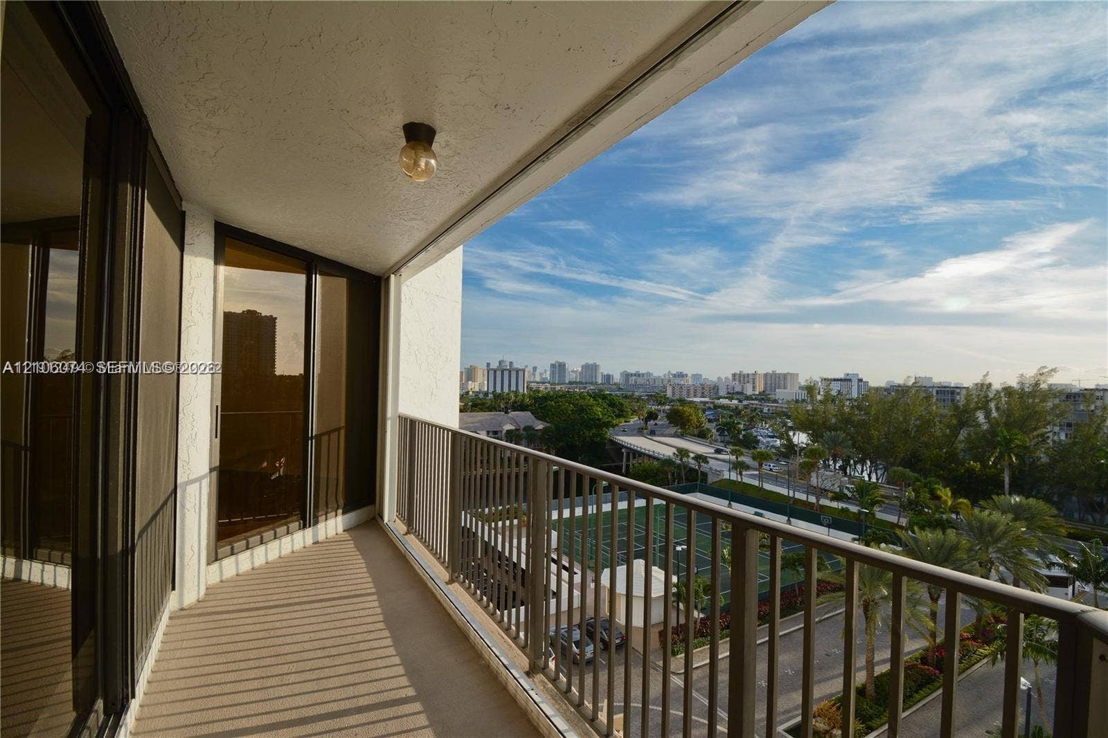 300 Three Islands Boulevard, #308, Hallandale Beach, Hallandale Beach, FL 33009 Covered balcony featuring metal railings, neutral textured flooring, ceiling-mounted lighting, and floor-to-ceiling glass sliding doors