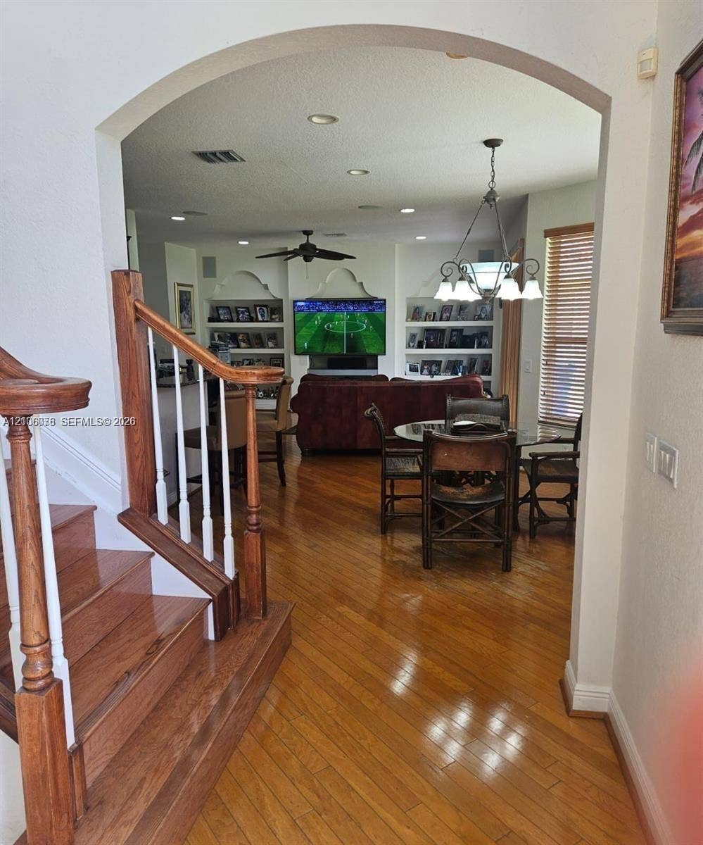 13382 Lakepointe Circle, #0, Cooper City, Cooper City, FL 33330 Elegant open-concept living space featuring warm wood-finish flooring, arched architectural detailing, and recessed ceiling lighting