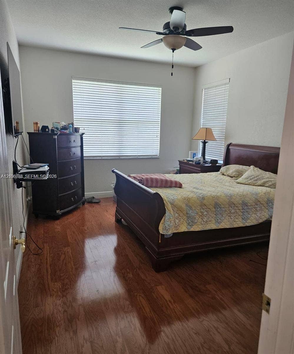 13382 Lakepointe Circle, #0, Cooper City, Cooper City, FL 33330 Bedroom featuring wood-finish flooring, dual windows with horizontal blinds, and a central ceiling fan with an integrated light fixture