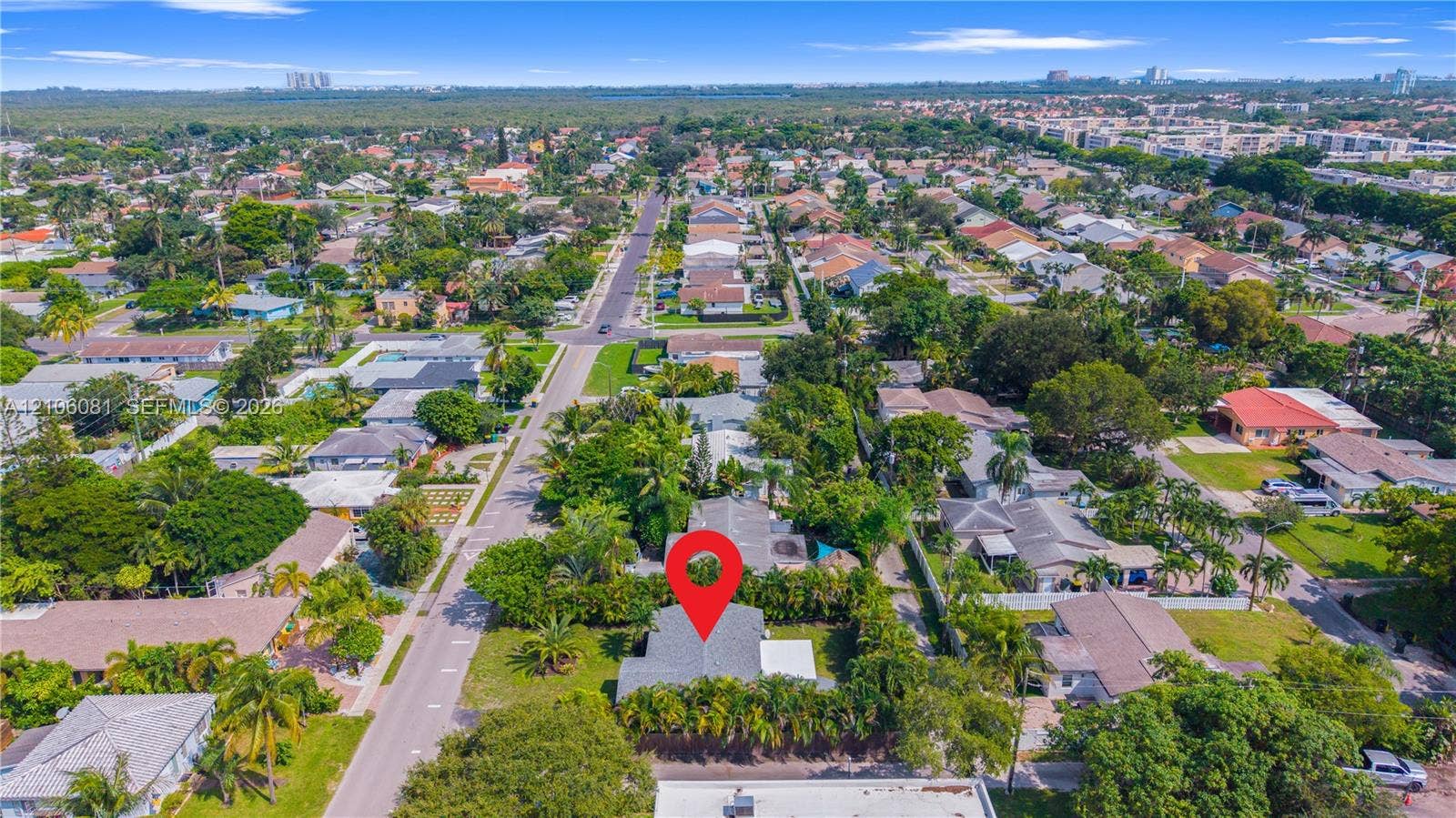 Aerial perspective of property featuring a shingled roof, surrounding mature landscaping, and established residential street infrastructure