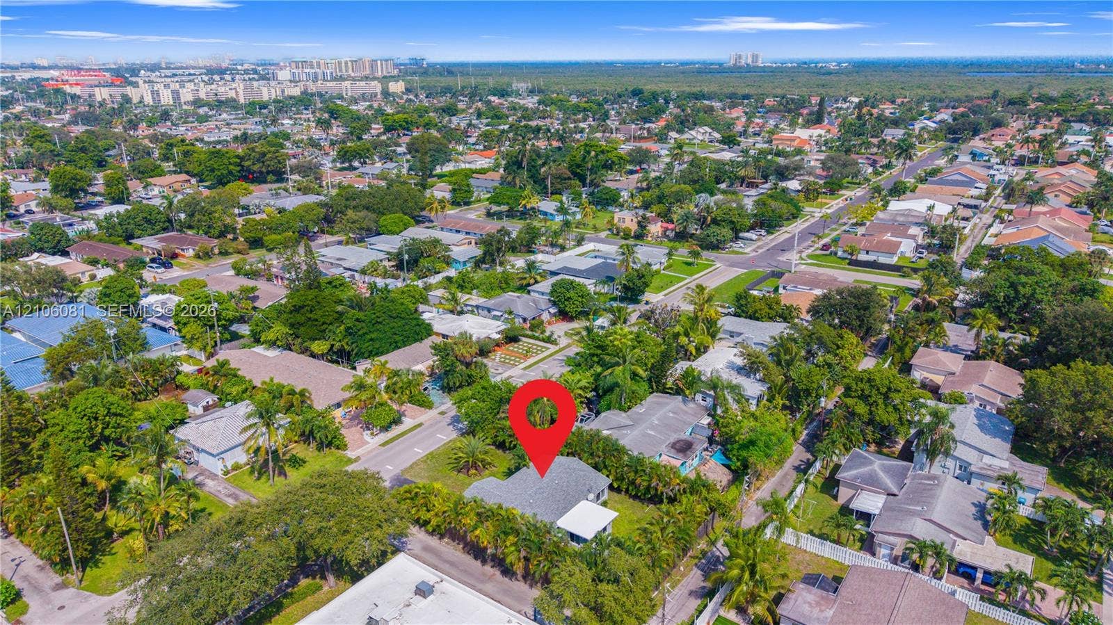 Aerial perspective featuring a shingled roofline, established perimeter vegetation, and expansive lot grounds situated within an established suburban setting