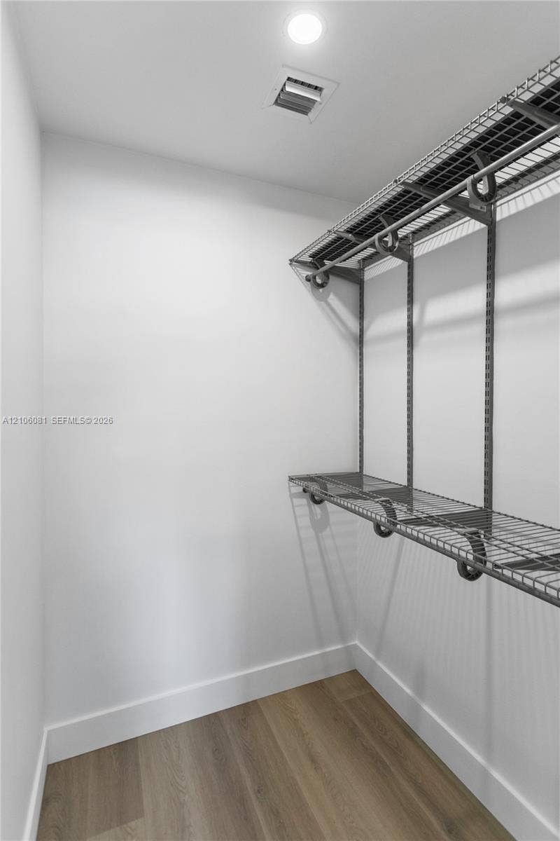 Storage area featuring wood-finish flooring and integrated multi-tier wire shelving