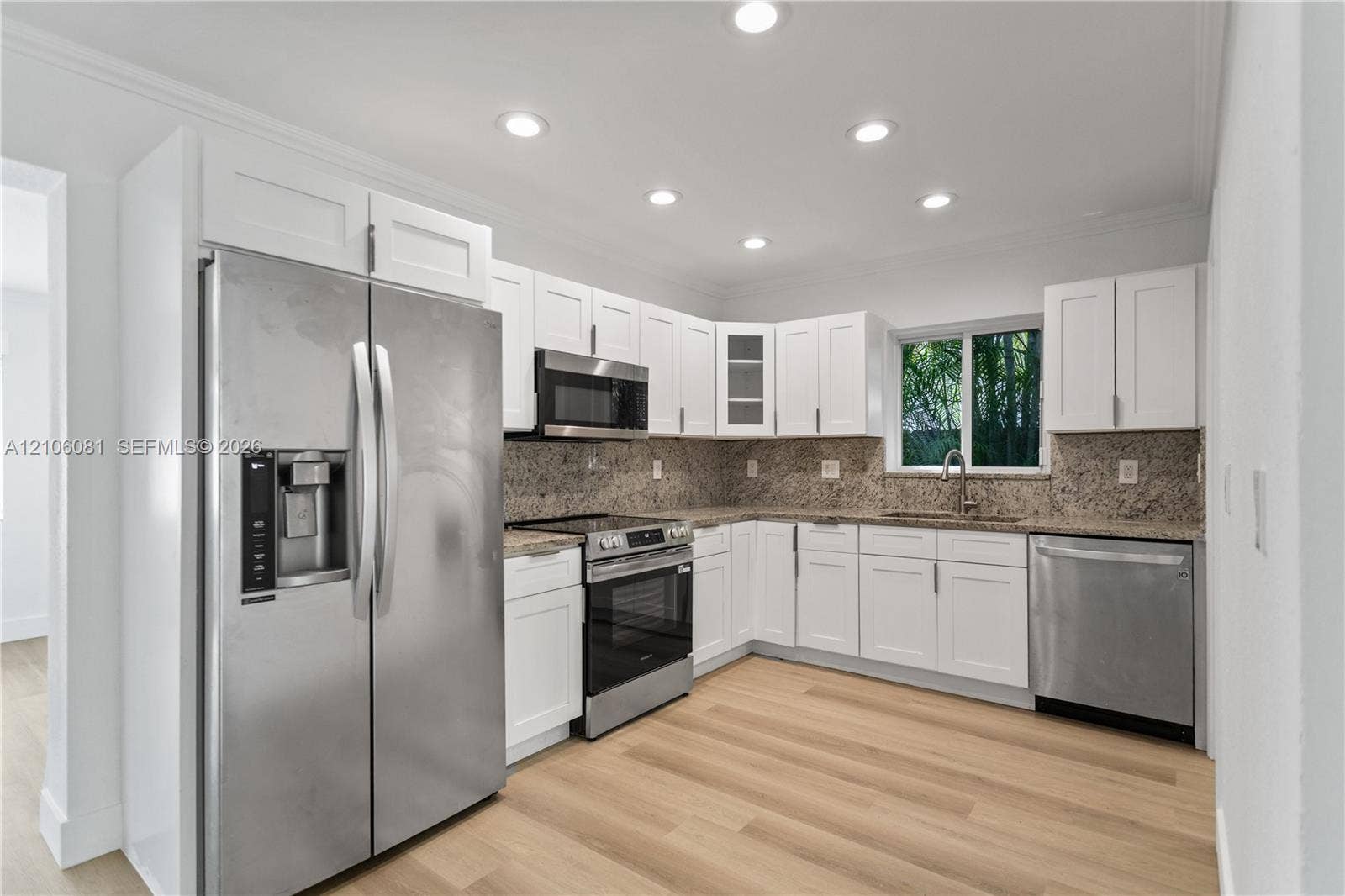 Kitchen featuring white cabinetry, stone countertops, stainless steel appliances, recessed lighting, and wood-finish flooring