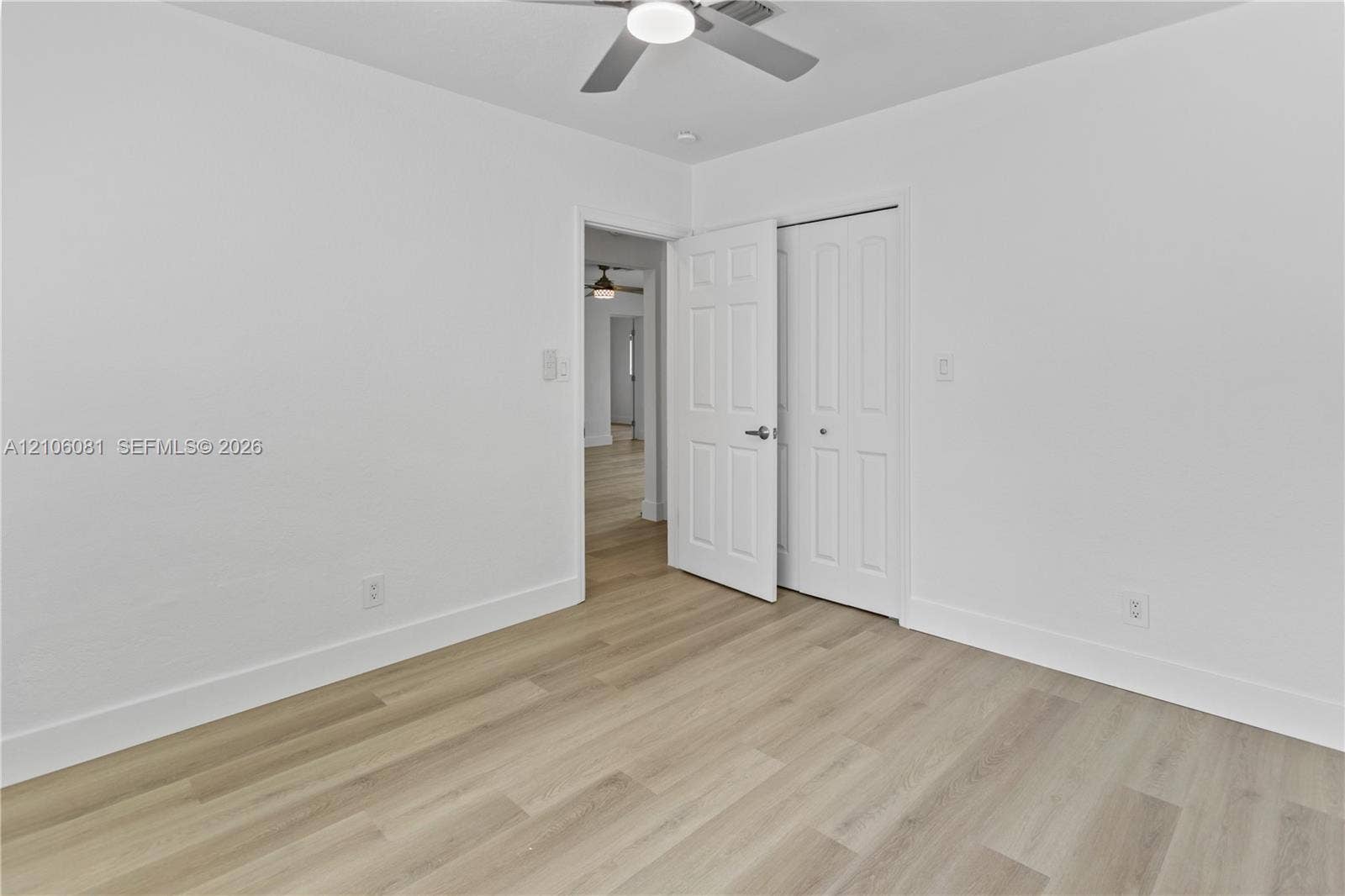Room featuring light-tone wood-finish flooring, a ceiling fan with integrated lighting, and a six-panel closet door