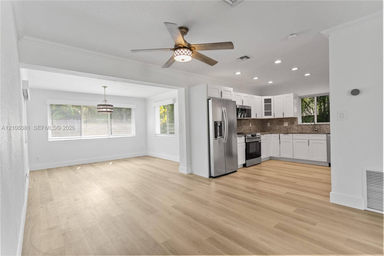 Kitchen featuring white cabinetry, stainless steel appliances, wood-finish flooring, recessed lighting, and a ceiling fan