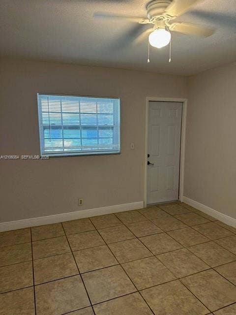 324 SE 10th Avenue, #1-8, Pompano Beach, Pompano Beach, FL 33060 Storage space featuring built-in vertical shelving, a horizontal hanging rod, and tile flooring, secured by a louvered bifold door
