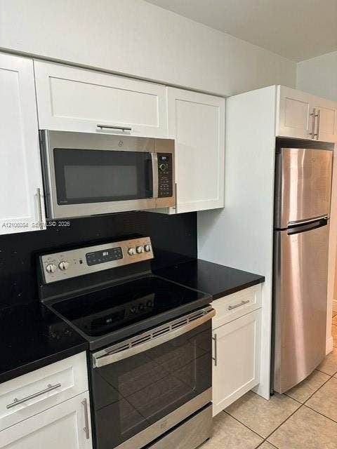 324 SE 10th Avenue, #1-8, Pompano Beach, Pompano Beach, FL 33060 Hallway featuring tile flooring, ceiling-mounted lighting, and louvered-style interior doors
