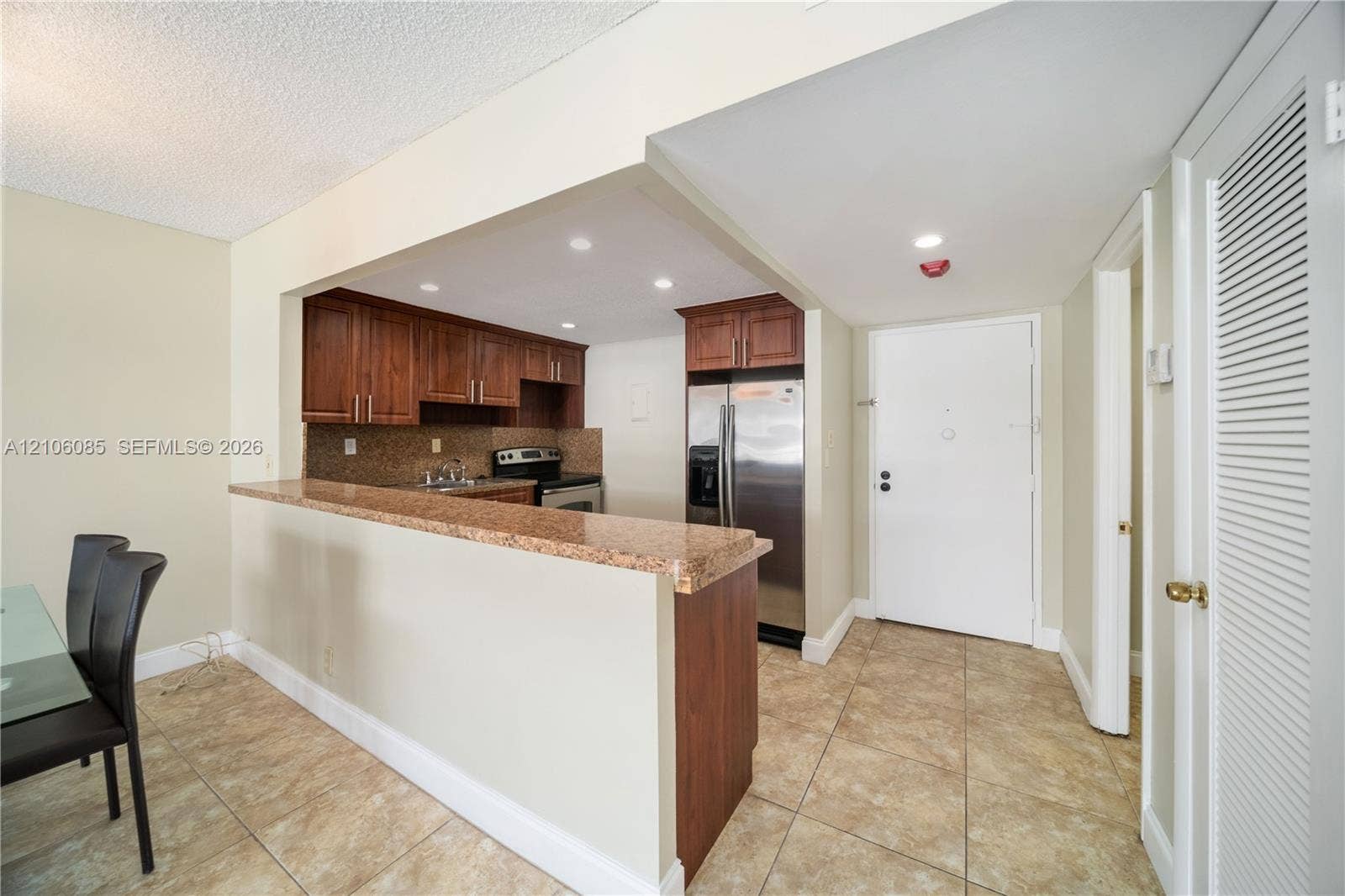 16710 NE 9th Avenue, #705, North Miami Beach, North Miami Beach, FL 33162 Kitchen featuring wood cabinetry, stone-surface breakfast bar, tile flooring, stainless steel appliances, and recessed lighting