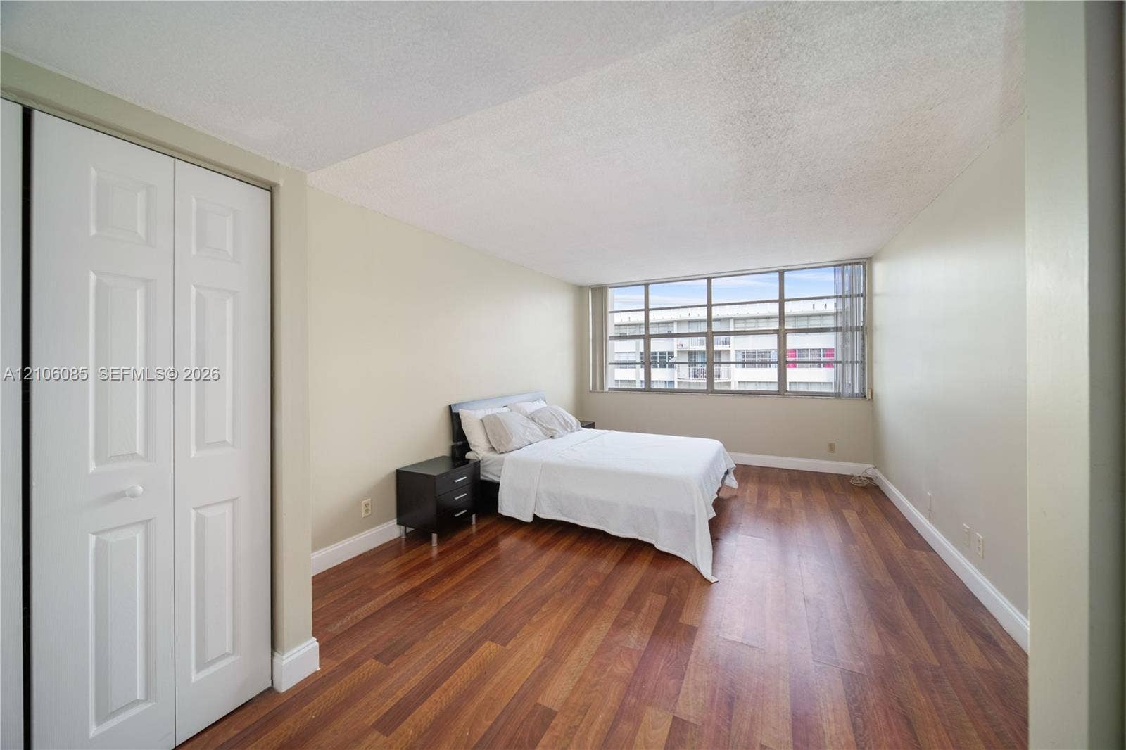 16710 NE 9th Avenue, #705, North Miami Beach, North Miami Beach, FL 33162 Room featuring wood-finish flooring, floor-to-ceiling multi-pane windows, and a built-in double-door closet