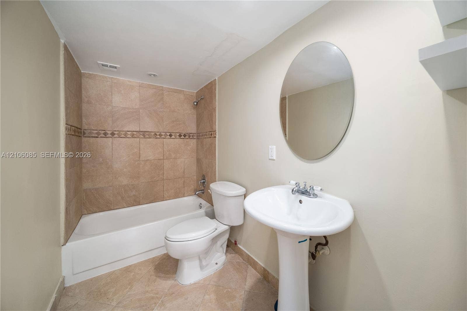16710 NE 9th Avenue, #705, North Miami Beach, North Miami Beach, FL 33162 Bathroom featuring a pedestal sink, oval wall-mounted mirror, tiled shower enclosure with decorative inlay, and tile flooring