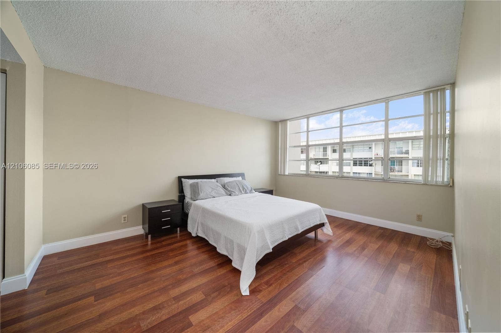 16710 NE 9th Avenue, #705, North Miami Beach, North Miami Beach, FL 33162 Spacious room featuring wood-finish flooring and expansive multi-pane windows with vertical blinds