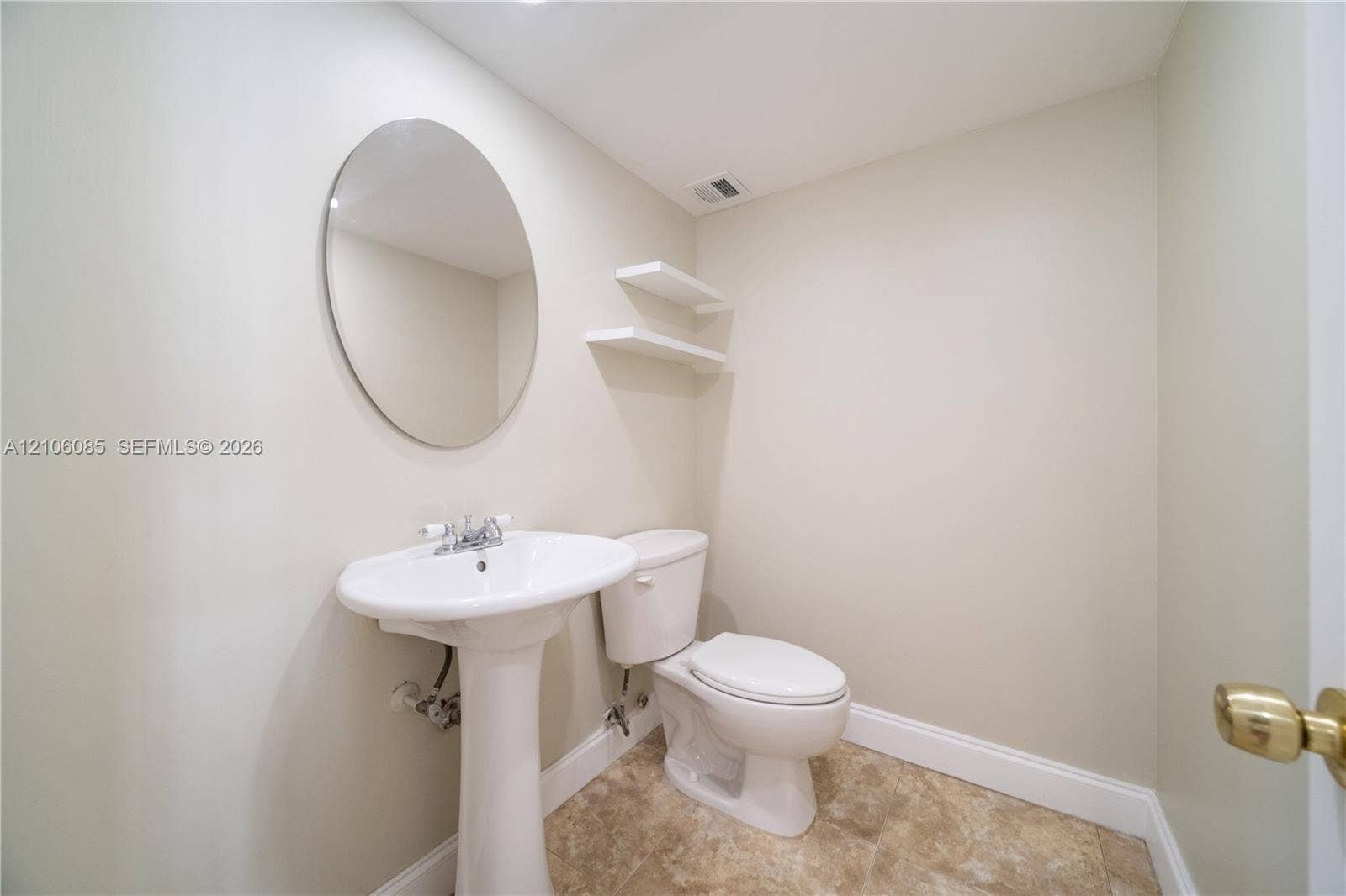 16710 NE 9th Avenue, #705, North Miami Beach, North Miami Beach, FL 33162 Ceramic pedestal sink with chrome faucet, oval wall-mounted mirror, two floating wall shelves, and tile flooring