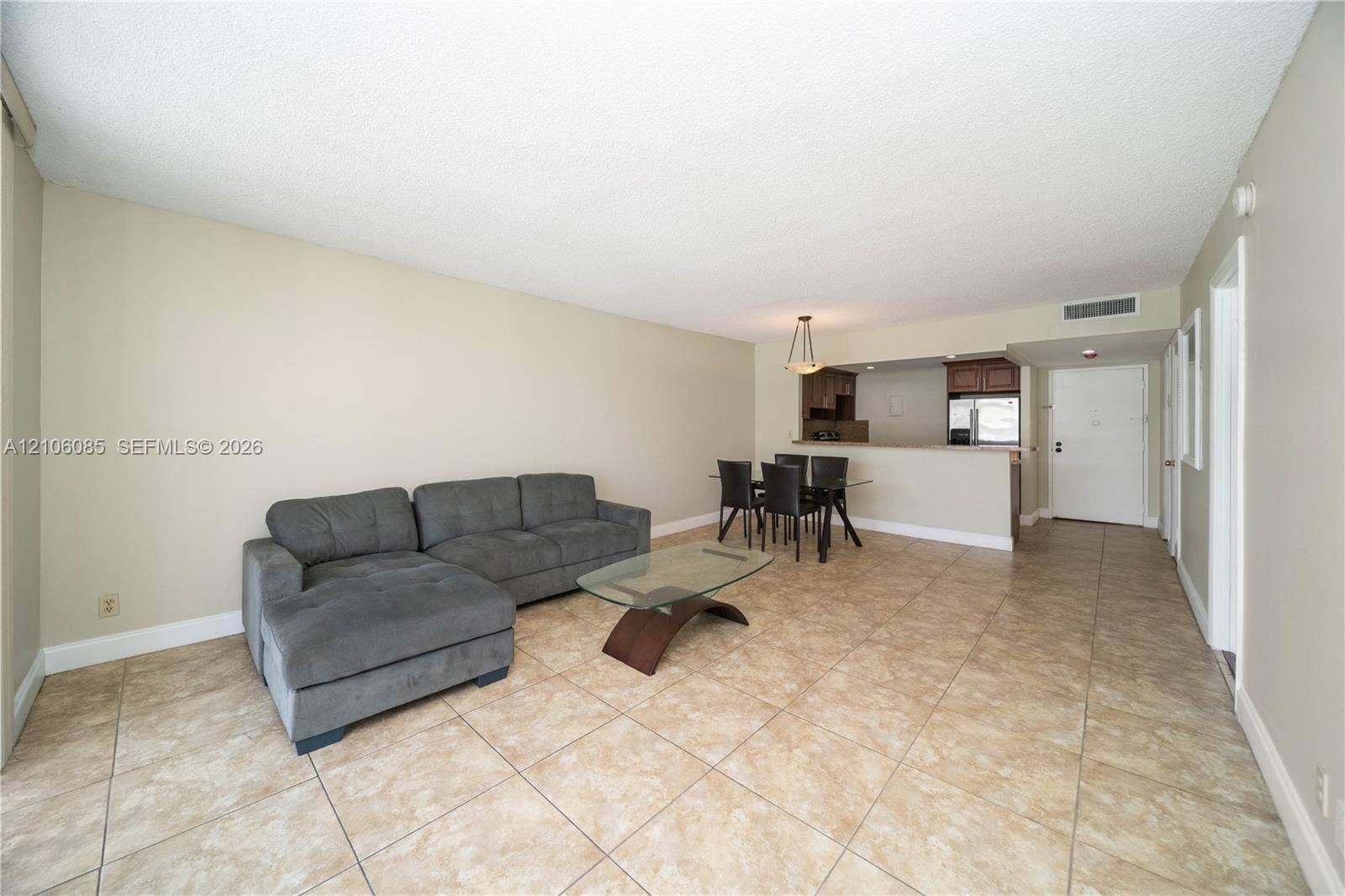 16710 NE 9th Avenue, #705, North Miami Beach, North Miami Beach, FL 33162 Neutral-toned interior featuring ceramic tile flooring, a breakfast bar, and a hanging pendant light fixture