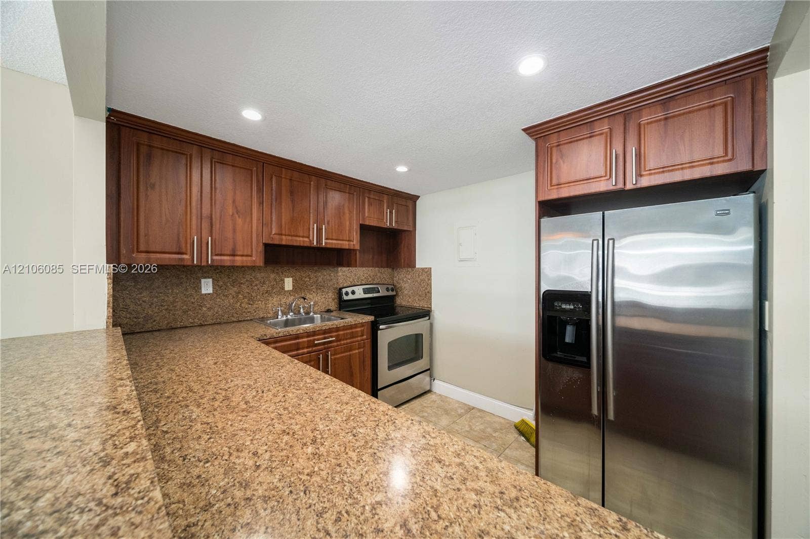 16710 NE 9th Avenue, #705, North Miami Beach, North Miami Beach, FL 33162 Kitchen featuring wood cabinetry, solid-surface countertops, stainless steel refrigerator, stainless steel range, and tile flooring
