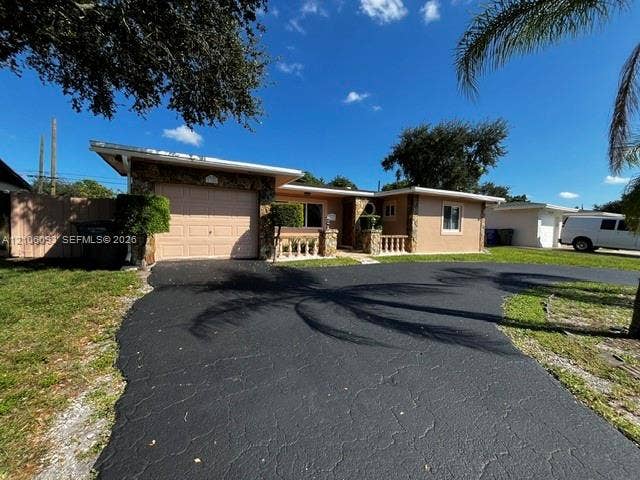 1325 N 74th Terrace, #0, Hollywood, Hollywood, FL 33024 Single-story exterior featuring stone veneer accents, a covered entryway with concrete balustrades, an attached one-car garage, and an asphalt driveway