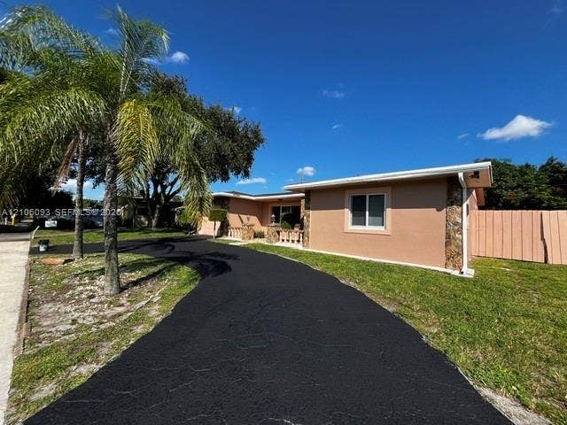 1325 N 74th Terrace, #0, Hollywood, Hollywood, FL 33024 Single-story exterior featuring a stucco finish, stone veneer accents, a paved driveway, and mature palm landscaping