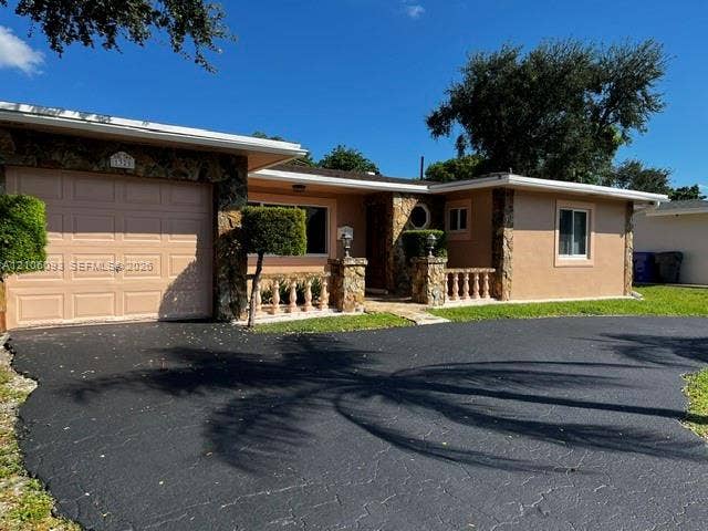 1325 N 74th Terrace, #0, Hollywood, Hollywood, FL 33024 Exterior featuring stone veneer accents, a paved driveway, and balustrade detailing