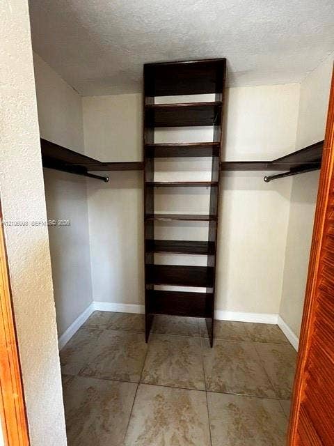 1325 N 74th Terrace, #0, Hollywood, Hollywood, FL 33024 Built-in vertical wood shelving tower, dual hanging rods, and tile flooring