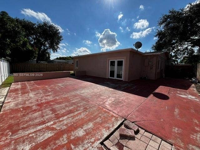 1325 N 74th Terrace, #0, Hollywood, Hollywood, FL 33024 Large concrete patio with low-profile perimeter wall, dual-pane glass French doors, and enclosed yard with wood-style fencing