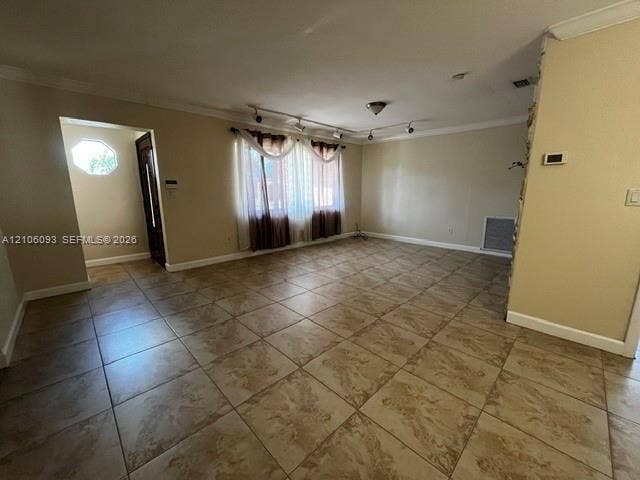 1325 N 74th Terrace, #0, Hollywood, Hollywood, FL 33024 Interior space featuring large-format tile flooring, crown molding, adjustable multi-head track lighting, and a stone-clad feature wall