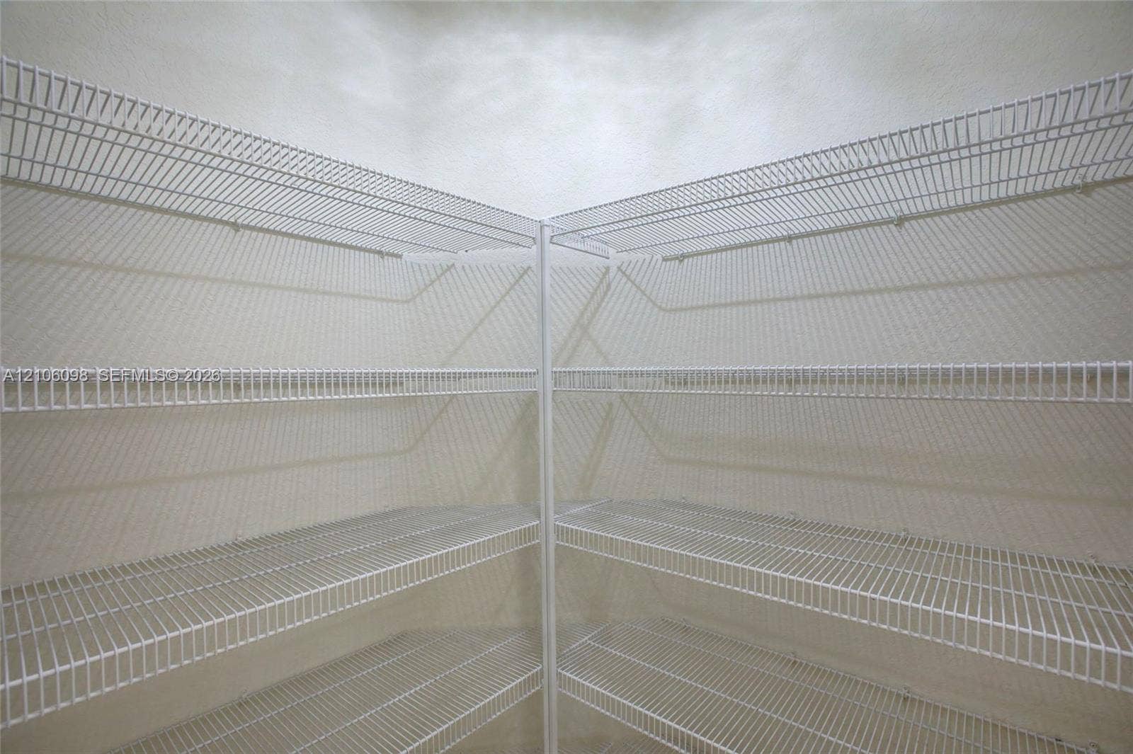 Corner storage area featuring white wire shelving across four tiers