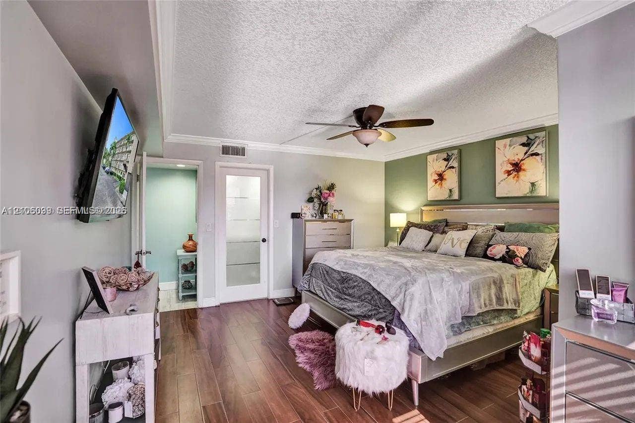 7840 NW 50th Street, #105, Lauderhill, FL 33351 Wood-finish flooring, ceiling fan with integrated light fixture, accent wall, and glass-paneled interior door