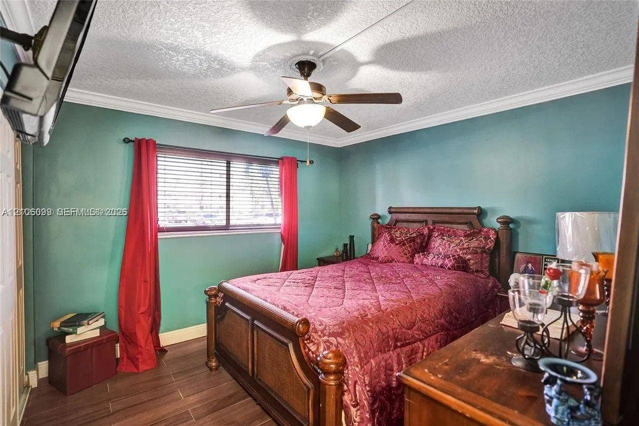 7840 NW 50th Street, #105, Lauderhill, FL 33351 Wood-finish flooring, ceiling fan with integrated lighting, crown molding, and horizontal blind window treatment