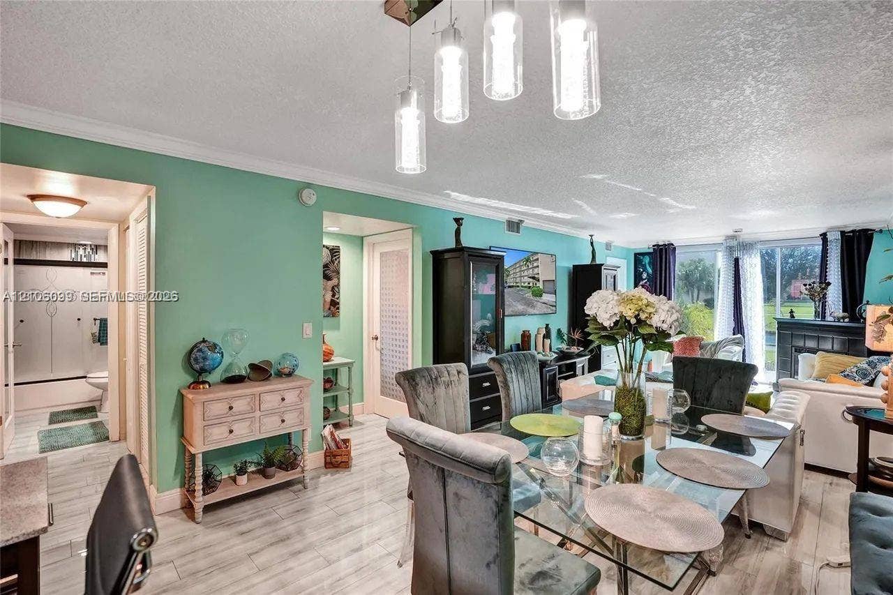 7840 NW 50th Street, #105, Lauderhill, FL 33351 Open-concept area featuring tile flooring, crown molding, modern multi-pendant lighting, and sliding glass doors