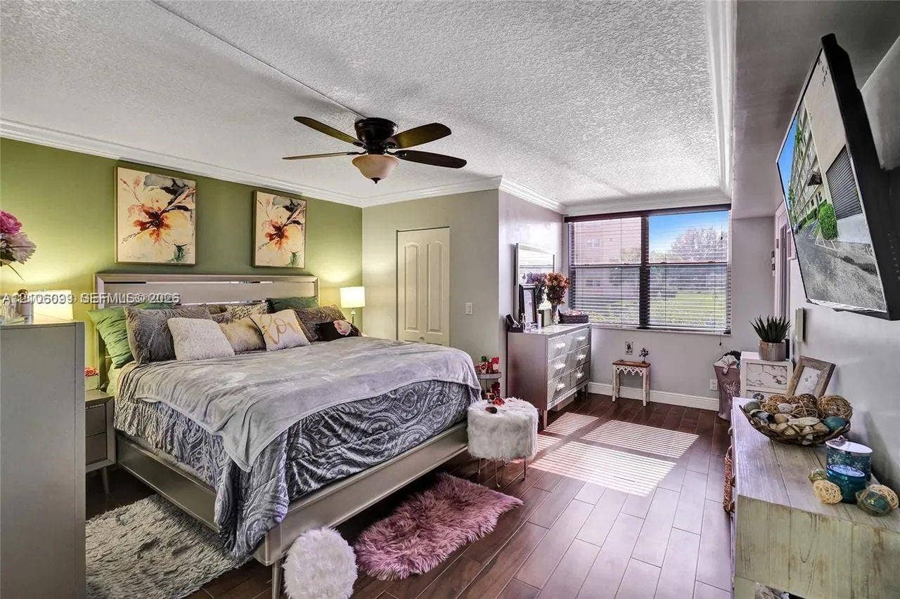 7840 NW 50th Street, #105, Lauderhill, FL 33351 Wood-finish flooring, ceiling fan with integrated lighting, window with horizontal blinds, and paneled closet door