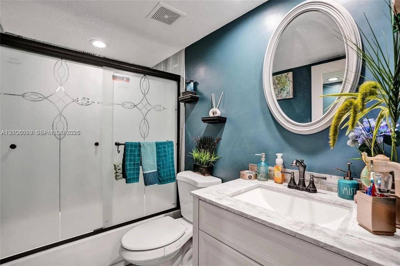 7840 NW 50th Street, #105, Lauderhill, FL 33351 Bathroom featuring a vanity with a light-toned countertop, integrated rectangular basin, and dark-finish widespread faucet
