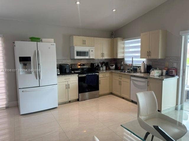 16284 SW 100th Terrace, Miami, FL 33196 Kitchen featuring off-white shaker cabinetry, polished stone countertops, tile backsplash, stainless steel appliances, and large-format tile flooring