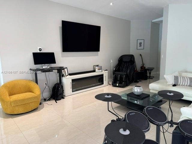 16284 SW 100th Terrace, Miami, FL 33196 Living area featuring large-format light-toned tile flooring, recessed ceiling lighting, and a built-in electric fireplace console