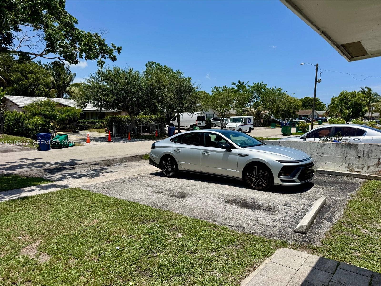 Asphalt surface parking area featuring concrete wheel stops and landscaped grass perimeter