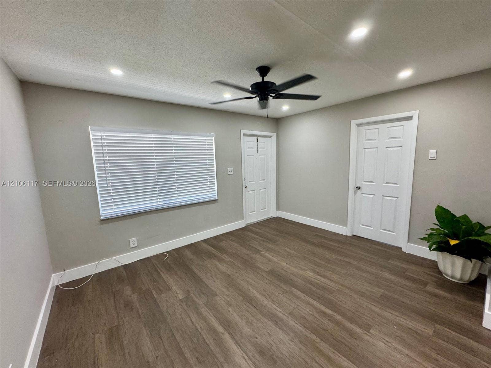 Interior space featuring wood-finish flooring, recessed lighting, a ceiling fan, and six-panel interior doors